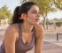 Runner wearing orange Shokz open-ear sports headphones outdoors in Oman