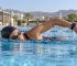 Swimmer wearing a GPS sports watch during an open-water swim in Oman